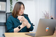 asian businesswoman hand and wrist pain during use computer in office long time