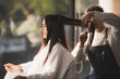 © chokniti - Asian long black straight  hair female cutting her hair at luxery salon with professional  dresser with scissor tool.