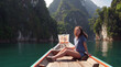 © skymediapro - Young Happy Mixed Race Girl Sitting and Relaxing on Traditional Thai Wooden Long Tail Boat at Khao Sok Lake. Phang Nga Province, Thailand.