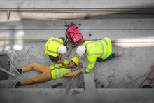 Basic First Aid And CPR For Emergency Accidents At Construction Sites. Construction Worker Was Injured In A Fall From A Height At Construction Site. Safety Team And Engineers Help To Perform First Aid