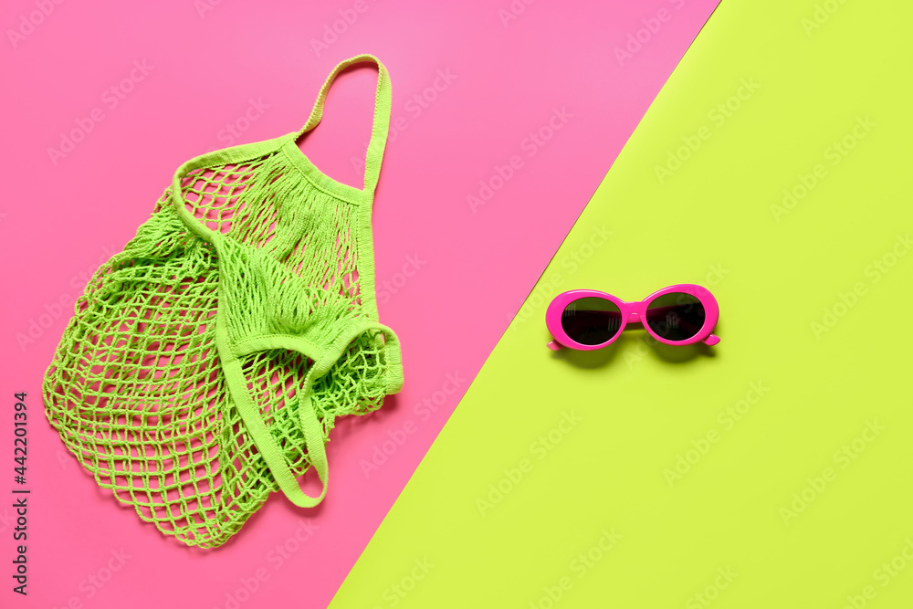 Stylish sunglasses and eco bag on color background