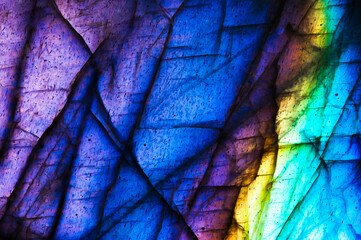 Detail of colorful multicolored (blue, yellow, purple, cyan) labradorite gemstone. Close-up of the texture background