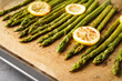 Fried asparagus and lemon on a baking sheet. Close-up