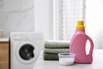 Wall Mural - Stack of folded towels and detergents on white table in bathroom, space for text