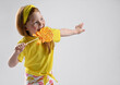 cute red-haired girl in a summer fashionable outfit, licking lollipops and hovering with pleasure with her second hand. Studio shot.