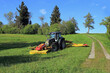 Ein Landwirt in Bayern mäht im Sommer das Gras auf einem Feld
