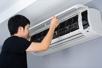 Wall Mural - man open the air conditioner indoor at home