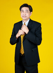 Senior businessman stand, touching black suit. Smiling look camera, Studio shoot with yellow background. Face feel relaxing, happy. Concept for CEO, Big boss.