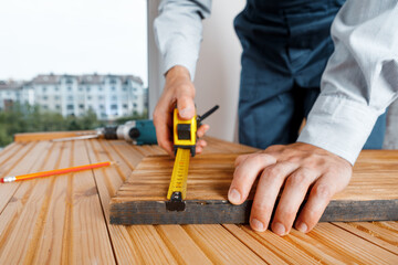 Handyman in blue uniform works with electricity automatic screwdriver. House renovation conception.