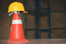 Orange Plastic Traffic Cone And Engineer's Hat In The Construction Building