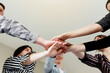 © Lena Ivanova - Group of people doing handshake and cross hands