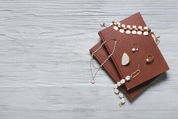 Books and stylish female accessories on grey wooden background