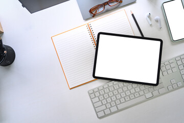 Top view white office desk with digital tablet, notebook, glasses and smart phone.