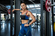 © nazarovsergey - Confident athletic girl standing near Smith machine at gym
