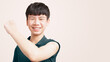 © myboys.me - COVID 19 Vaccines for teenagers concept. Studio portrait of a healthy Asian teen boy lift his arm up to show the band aid from first dose vaccine shot. Against coronavirus, Back to school, Smile
