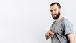 © Daria Lukoiko - Portrait of cheerful young handsome man smiling looking at camera pointing finger forward on white background with space for advertising mock up