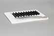 Tablet with false eyelashes and tweezers on a gray background. Cosmetic accessories for eyelash extensions