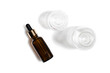 Glass cosmetic bottles on a white background. View from above. One of them is brown and with a pipette.