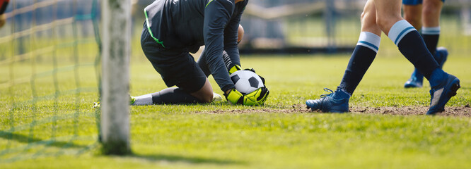 Football Goalkeeper on Knees in Action Catching Ball. Goalie Saving Goal. Horizontal Soccer Background. Players Kicking Football Match on Grass Turf