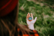 A girl in a red checkered shirt holds a compass in her hand, orienteering, the concept of finding a goal, a hipster woman in a red hat walks in the woods