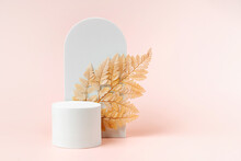 White Podium With Branch Of Leaves And Arch To Show Cosmetic Products. Beige Color Background For Branding And Packaging Presentation.