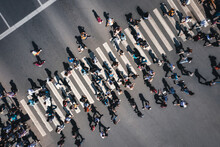 Different People At A Pedestrian Crossing In The City. People At A Zebra Pedestrian Crossing - A Lot Of Pedestrians In An Overcrowded City On A Sunny Day. Aerial Drone Shot. 