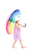 © Mediaphotos - Vertical full length studio portrait of cute Caucasian girl wearing summer dress and hat holding colorful umbrella posing on camera, white background