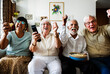 © Rawpixel.com - Group of cheerful senior friends sitting and watching TV together