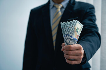 businessman in a suit Presenting dollar bills.