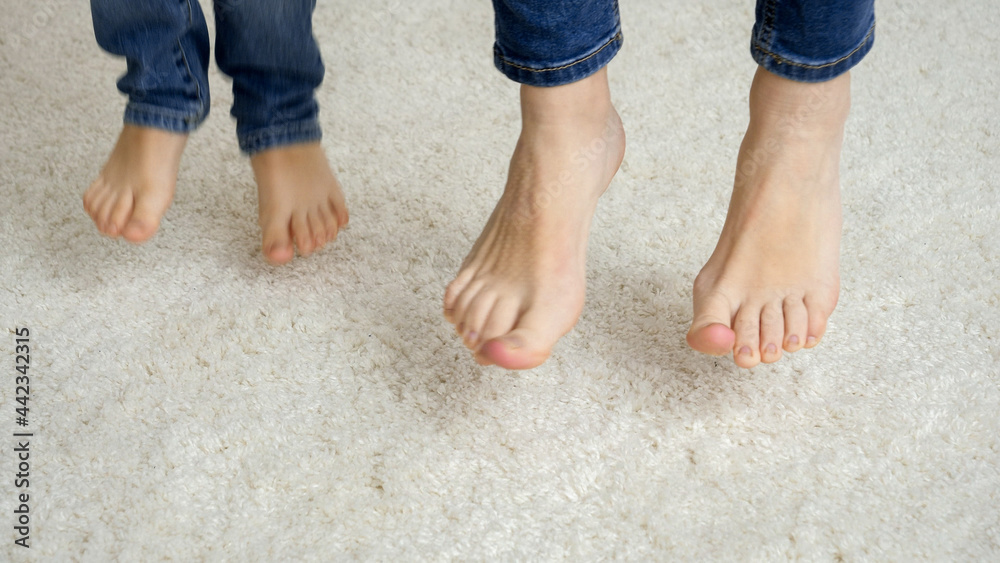 Closeup of mother and child feet jumping on soft carpet Stock Photo ...