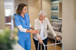 © Rido - Nurse helping senior woman to walk at private clinic