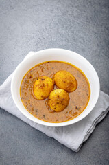 Wall Mural - Fried egg curry or anda masala served in a white bowl and copy space