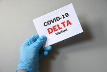 Doctor's Hand In Blue Glove With White Paper And Text Covid-19 Delta Variant. Concept Of Medical Variety Delta Variant And COVID-19. Concept Words 'delta Variant'. COVID-19 Delta Variant Concept.