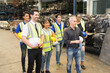 © Chaiya - Men and woman work together, show teamwork by holding helmets and looking at right side. Caucasian engineer men, black woman, Asian men, Asian woman holding helmets act as smart in factory-warehouse