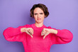 Portrait of sad girl show not approve sign wear pink sweater isolated on violet color background