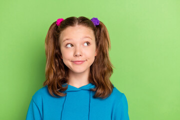 Poster - Photo of happy curious nice young small girl look empty space imagine dream isolated on green color background