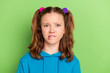 Photo of unhappy young doubtful young small girl bite teeth lips bad mood negative isolated on green color background