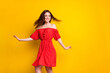 Photo portrait of funky girl laughing in red fancy printed dress dancing at party isolated vivid yellow color background empty space