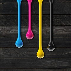 Wall Mural - cmyk ink drops on black wooden square background