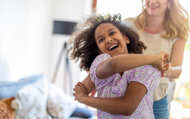 Little girl dancing with her mother at home
