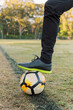© Austockphoto - Close up shot of a man stepping on a soccer ball with one foot on the field