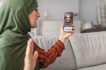 Wall Mural - Senior Islamic Lady Making Video Call Talking With Daughter Indoor