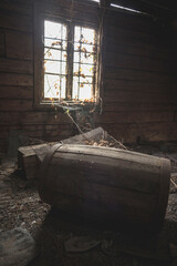 Wall Mural - Horror background causing fear. Scary mystical mysterious dark attic room in an abandoned wooden old house with a strange ghostly light on the floor from the window. Barrel on ground