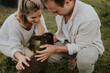 © Alina Schessler - Couple petting a young baby lamb on a farm