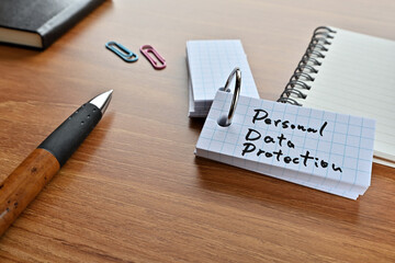 Poster - There is a word book with the word Personal Data Protection written on it with a pen and notebook.