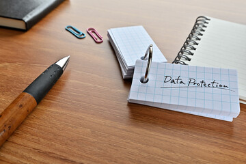 Poster - There is a word book with the word Data Protection written on it with a pen and notebook.
