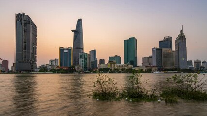 Wall Mural - Time lapse riverside city sunset sky and night brighter coal sparkling skyscrapers along beautiful river in Ho Chi Minh City, Vietnam