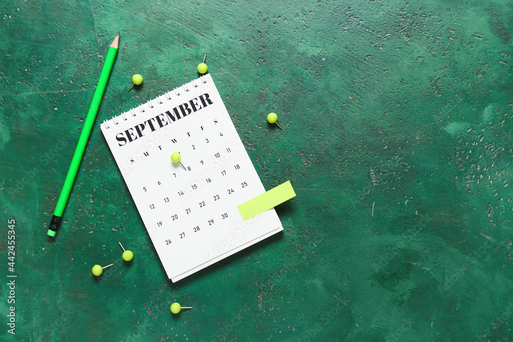 Flip paper calendar, pencil and pins on color background