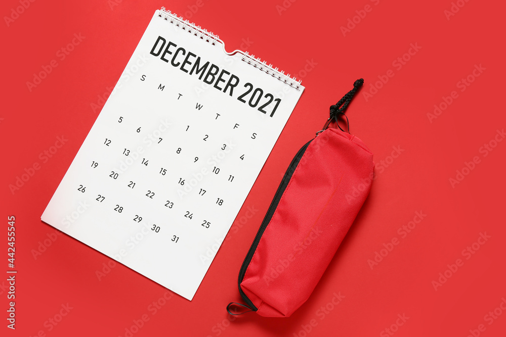 Flip paper calendar and pencil case on color background