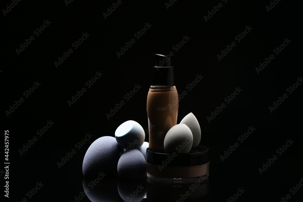 Makeup sponges and foundation on dark background